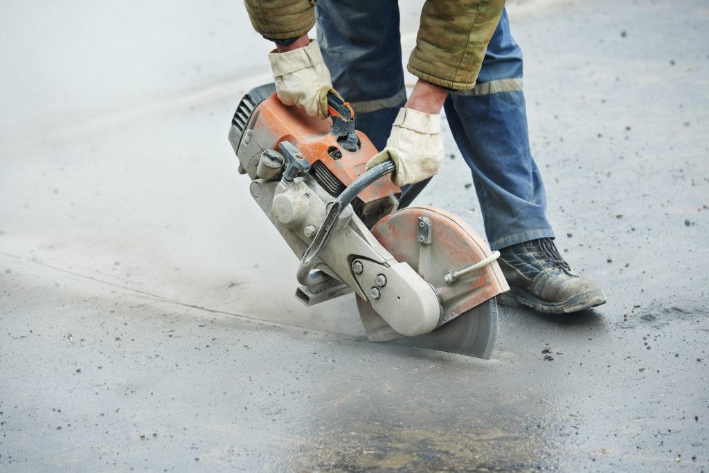 worker cutting asphalt saw